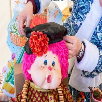 Des Jouets En Peluche Faits à La Main Sont Vendus à La Foire Artisanale Une Femme Met Un Béret Sur Une Poupée